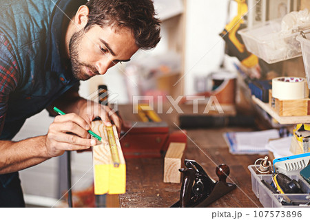 Carpenter, wood and drawing with man in workshop for building, manufacturing and creative. Planning, industry and woodworker with handyman measuring on workbench for builder, lumber and maintenance 107573896