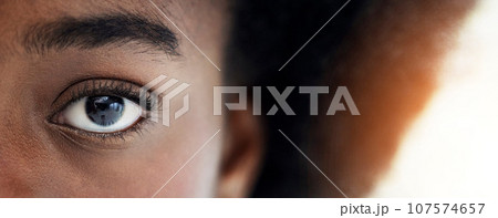 Eyes, closeup and portrait of African woman with mockup space for focus, thinking and vision. Banner, lens flare and zoom of half face of person looking for perception, awareness and intense stare 107574657