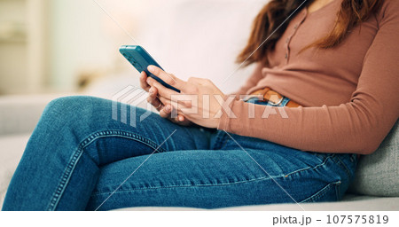 Sofa, home and hands typing on smartphone chat, social media or networking connection on mobile app, internet or house wifi. Teenager girl or woman with cellphone technology texting message in lounge 107575819