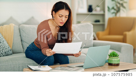 Woman, paper and laptop in living room on sofa working on project, assignment or task for college or business. Student, girl and home to study, for test or exam at university with handheld movement 107575985
