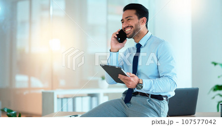 Business man talking on a phone while browsing on a digital tablet in an office. Dedicated sales executive and young expert communicating project plans and discussing deals with clients in a company Business man talking on a phone while browsing on a digital tablet in an office. Dedicated sales executive and young expert communicating project plans and discussing deals with clients in a company 107577042