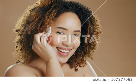 Cotton, skincare or portrait of a happy woman in studio for cleaning, beauty or dermatology treatment. Brown background, face or proud model with pad for facial, toner and cosmetics with mockup space 107577062