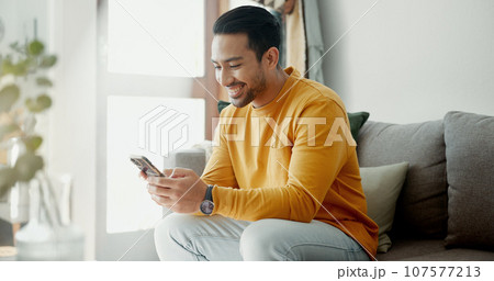 Man hands, phone texting and home with social media post, networking and online on a sofa. Mobile app, message and typing on a living room couch with digital entertainment and smile on tech in house 107577213