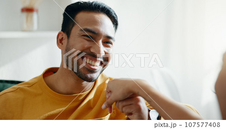 Holding hands, smile and couple on a sofa, relax and bond with conversation, romance and care at home. Happy, love and man in a living room with trust, support and smile while speaking in a house Holding hands, smile and couple on a sofa, relax and bond with conversation, romance and care at home. Happy, love and man in a living room with trust, support and smile while speaking in a house 107577408