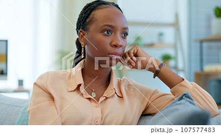 Thinking, worry and black woman on couch with a problem, crisis and ideas of stress in a home living room. Fear, house and person scared and anxious about a mistake, fail or unhappy on a sofa 107577483