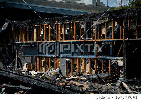 A burnt-out old wooden building after a fire. Charred beams after the destruction. 107577641