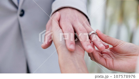 Couple, holding hands and ring for marriage, wedding or ceremony for commitment, love or support. Closeup of people getting married, vows or accessory for symbol of bond, relationship or partnership Couple, holding hands and ring for marriage, wedding or ceremony for commitment, love or support. Closeup of people getting married, vows or accessory for symbol of bond, relationship or partnership 107578976