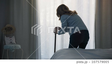 Balance, medical and window with old woman and walking stick in bedroom for wellness, retirement and healthcare. Depression, mental health and nursing home with patient with a disability for support Balance, medical and window with old woman and walking stick in bedroom for wellness, retirement and healthcare. Depression, mental health and nursing home with patient with a disability for support 107579005