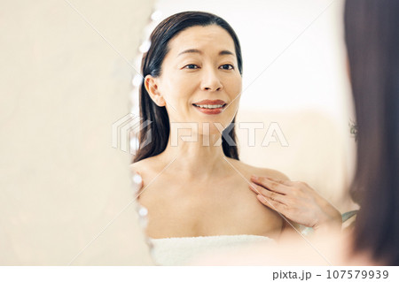 洗面台の鏡を見るミドル女性 107579939