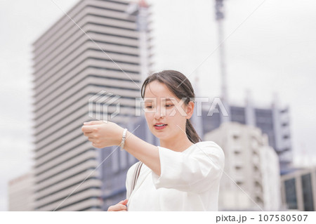 時計を見る女性 107580507