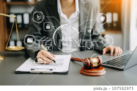 AML Anti Money Laundering Financial Bank Business Concept. judge in a courtroom using laptop and tablet with AML anti money laundering icon on virtual  screen. . 107582973