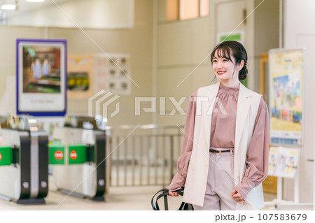 駅・空港でスーツケースを持って出張・旅行に出かける女性 駅・空港でスーツケースを持って出張・旅行に出かける女性 107583679