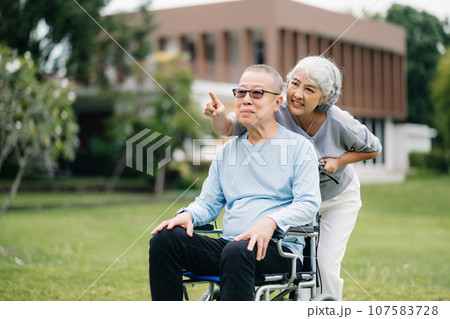 Asian senior couple having a good time. They laughing and smiling while sitting outdoor at the park. Lovely senior couple. 107583728