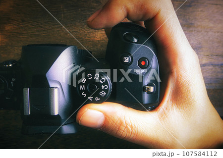 デジタルカメラのグリップを握る男性の手 デジタルカメラのグリップを握る男性の手 107584112