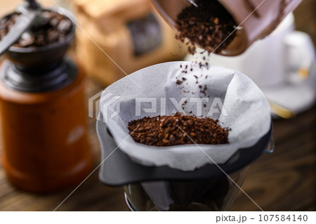 ホットコーヒーに挽いたコーヒー豆を入れる ホットコーヒーに挽いたコーヒー豆を入れる 107584140