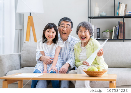 孫娘と団欒するシニアの夫婦 107584228