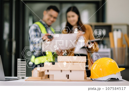 Engineer desk with object paper and tablet with blurry engineer teamwork hardworking to consults about their building project... 107584517