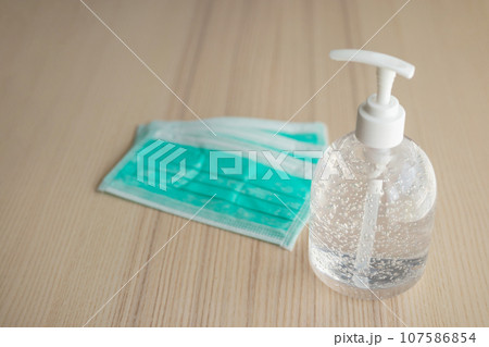 Medical face mask with alcohol sanitizer gel hand wash on wood table for covid-19 Coronavirus prevention concept 107586854