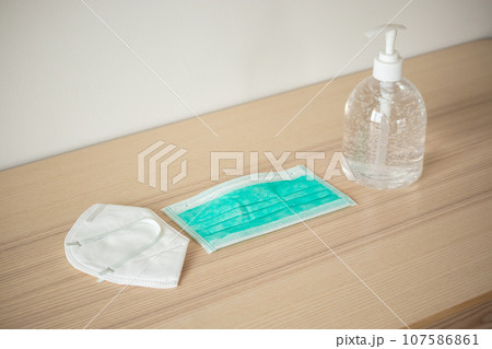 Medical face mask with alcohol sanitizer gel hand wash on wood table for covid-19 Coronavirus prevention concept 107586861