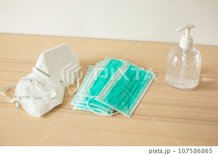 Medical face mask with alcohol sanitizer gel hand wash on wood table for covid-19 Coronavirus prevention concept 107586865