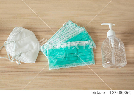 Medical face mask with alcohol sanitizer gel hand wash on wood table for covid-19 Coronavirus prevention concept 107586866