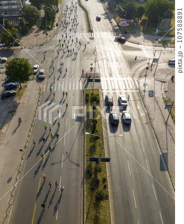 Aerial drone Shot of street Marathon in Skopje, Republic of North Macedonia. Crowd of running people on the city streets 107588891