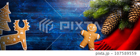 Christmas Tree Decoration On Blue Wooden Background; greeting card or banner design Christmas Tree Decoration On Blue Wooden Background; greeting card or banner design 107589559