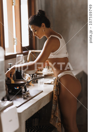 Stylish Cooking Sexy Woman in Lingerie During Breakfast Cook, Kitchen Stylish Cooking Sexy Woman in Lingerie During Breakfast Cook, Kitchen 107589749