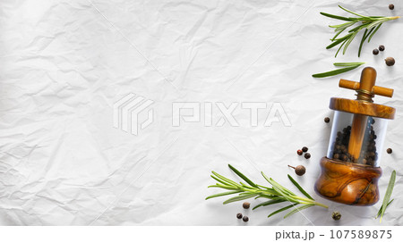 traditional italian pepper shaker and green organic rosemary leaves on white culinary paper background. Ingredient, spice for cooking. collection for culinary banner design traditional italian pepper shaker and green organic rosemary leaves on white culinary paper background. Ingredient, spice for cooking. collection for culinary banner design 107589875