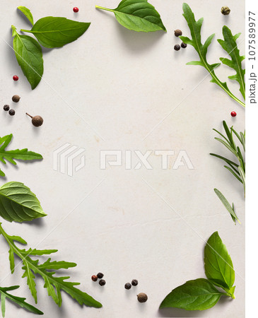 Art frame / border italian cooking background; old parchment with fresh mediterranean herbs leaves; Basil rosemary arugula 107589977