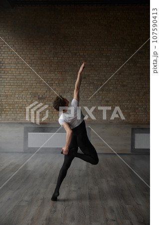 Contemporary ballet male dancer posing for camera performing body stretching 107590413