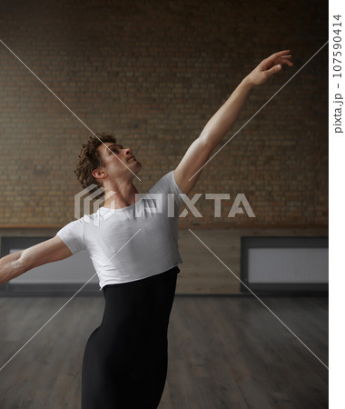 Male dancer practicing in ballet studio holding training class 107590414