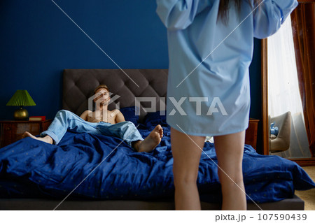 Woman undressing for man lying on bed performing prelude game Woman undressing for man lying on bed performing prelude game 107590439
