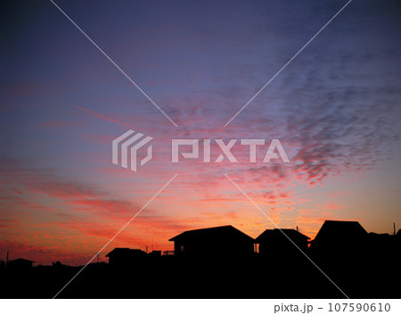 幻想的な夕焼け雲と民家のシルエット 幻想的な夕焼け雲と民家のシルエット 107590610