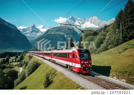 A locomotive pulls a passenger train along a winding road among the summer forest and mountains. 107591621