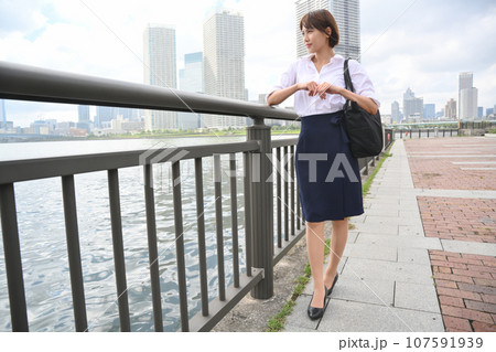 川べりの手すりから遠くを眺める女性 107591939