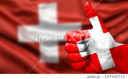 thumbs up in approval with the Swiss flag painted 107592713