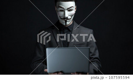portrait hacker wearing suit holding the laptop on grey isolated background portrait hacker wearing suit holding the laptop on grey isolated background 107595594