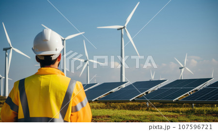 Close-up engineer and worker talking at work wind turbine and solar panel 107596721