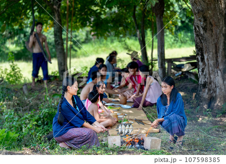 Group of Asian farmer family with young boy carry plow to join lunch during cultivate or working Group of Asian farmer family with young boy carry plow to join lunch during cultivate or working 107598385