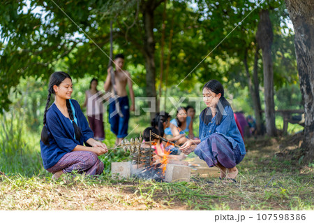 Group of Asian farmer family with young girl, boy, child enjoy to have lunch during cultivate work Group of Asian farmer family with young girl, boy, child enjoy to have lunch during cultivate work 107598386