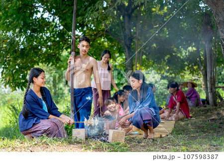 Asian young teenage boy carry plow come to join with Asian farmer family to have lunch Asian young teenage boy carry plow come to join with Asian farmer family to have lunch 107598387