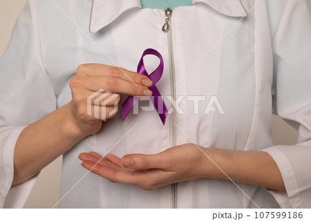 Violet purple ribbon awareness symbolic bow color in doctor's hand for Pancreatic cancer, Hodgkin's lymphoma, epilepsy and Testicular Cancer 107599186