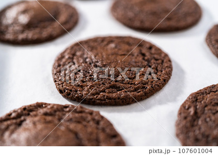 Cooling freshly baked chocolate cookies with chocolate hearts for Valentine's Day on a kitchen counter. Cooling freshly baked chocolate cookies with chocolate hearts for Valentine's Day on a kitchen counter. 107601004