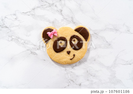 Panda-shaped shortbread cookies with chocolate icing on the kitchen counter. Panda-shaped shortbread cookies with chocolate icing on the kitchen counter. 107601186