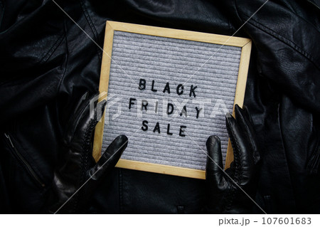 Hands in black gloves hold a frame with the inscription - Black Friday sale Hands in black gloves hold a frame with the inscription - Black Friday sale 107601683