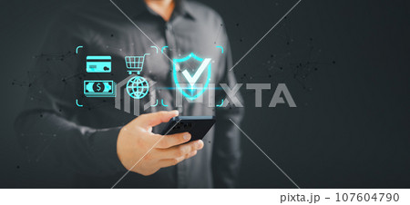 Customer use a mobile phone with the sign of security protection systems on virtual screen. Internet and Shopping online, Guarantee, Standards, Certified guarantee approval or secure access system. 107604790