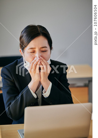 花粉症でくしゃみや鼻水がとまらない若い女性 107606504