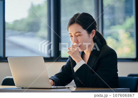 風邪をひいて咳をする若い女性 107606867