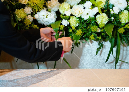 お花の手直しをする花屋さん 107607165